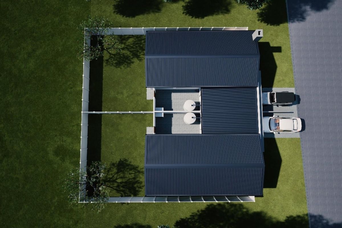 An aerial view of a residential property featuring a metal roof, private garden, paved courtyard, and driveway parking.