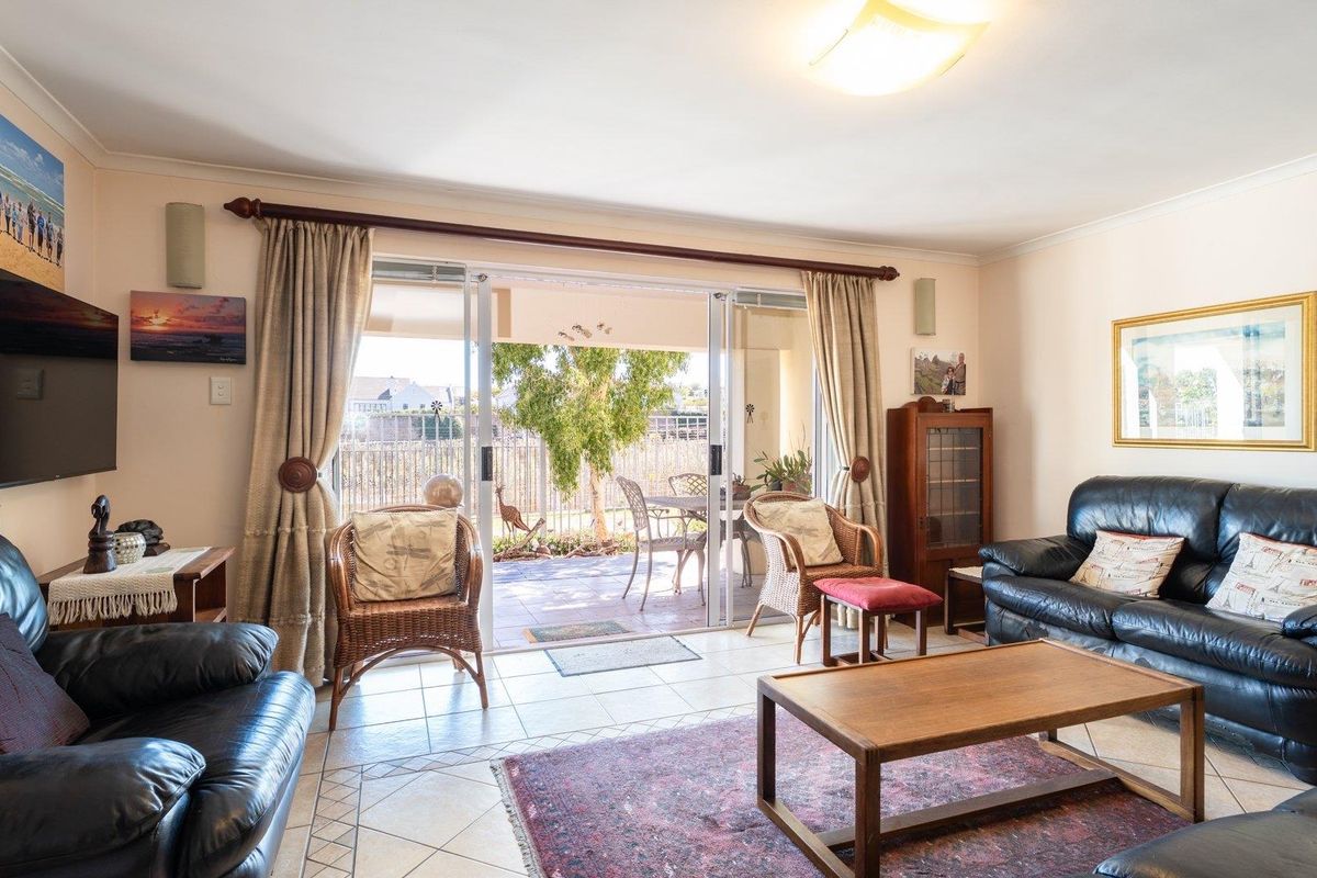 Spacious living room featuring ceramic tile flooring and large sliding glass doors that provide direct access to the outdoor patio area.