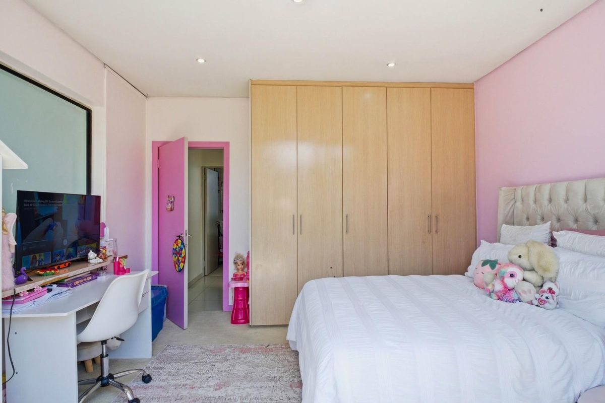 A well-maintained bedroom featuring ample built-in wooden cupboards and recessed ceiling lighting, providing a functional and organized living space.