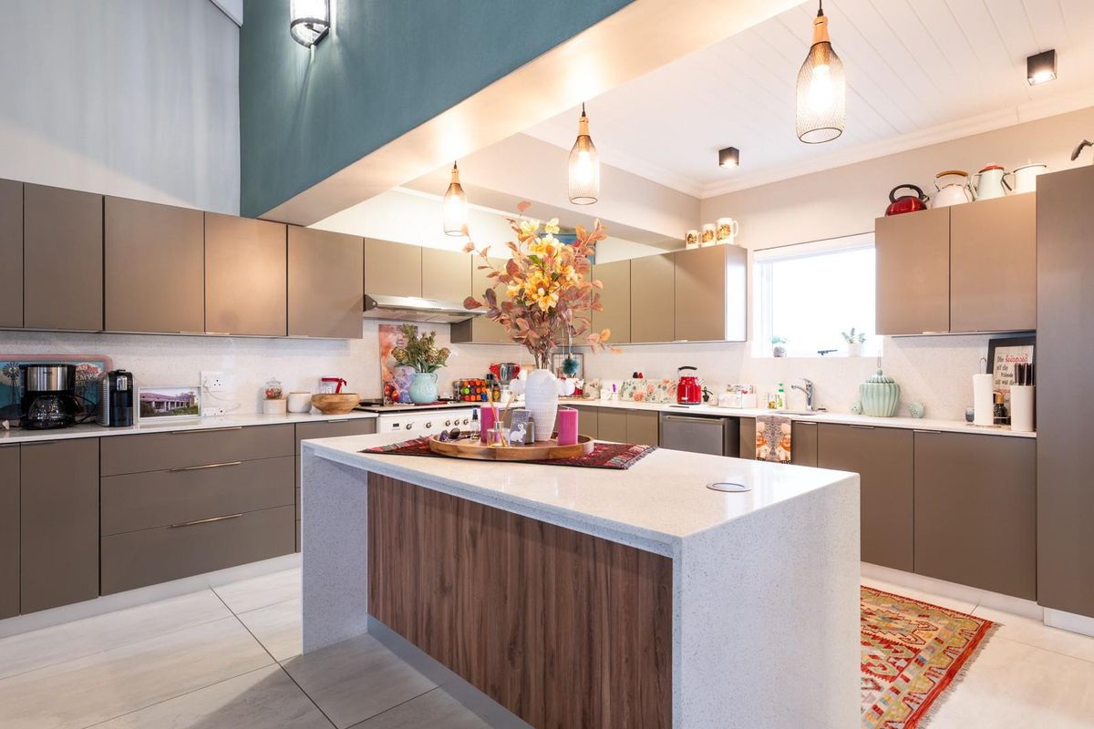 Modern kitchen featuring sleek cabinetry, a central island with stone countertop, integrated lighting, and high-quality finishes throughout.