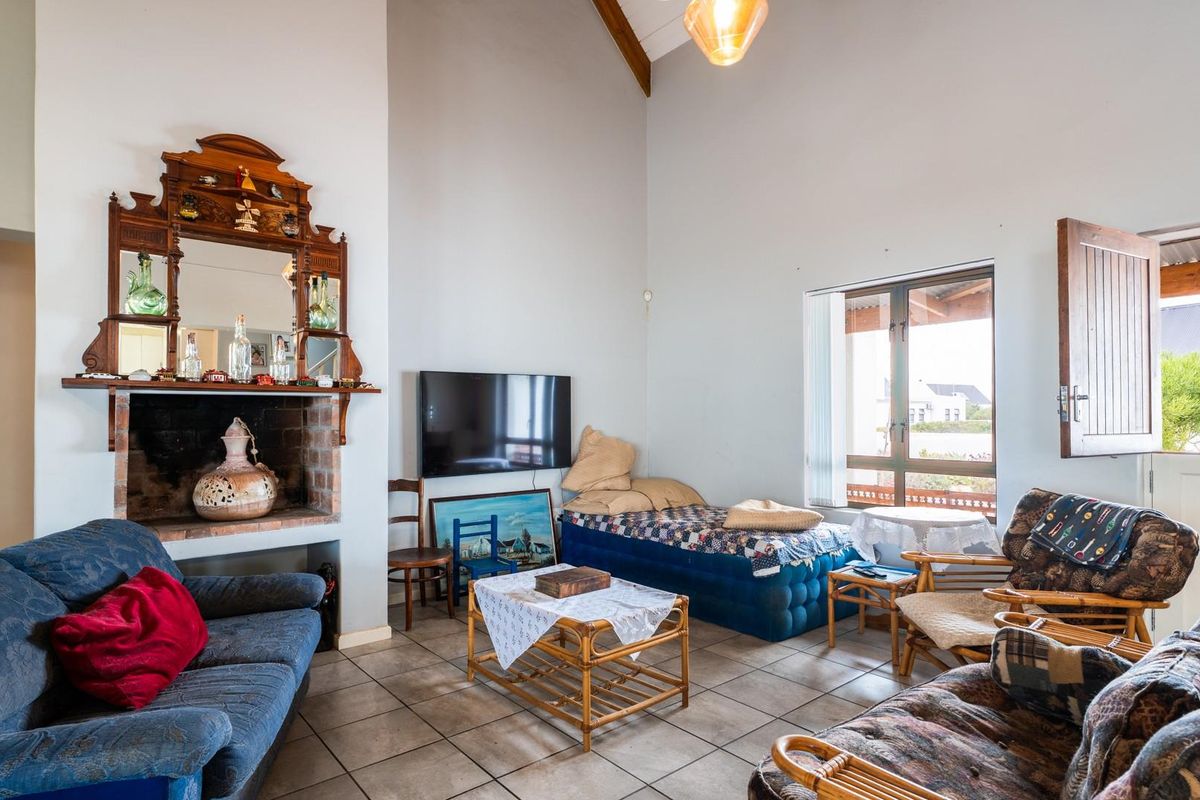 Spacious living room featuring a brick fireplace, vaulted ceilings, and tiled flooring, offering a comfortable area with direct access to the outdoor space.