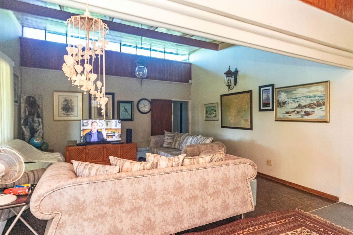 Spacious living room featuring high ceilings with exposed timber beams and clerestory windows, creating a bright and airy atmosphere.