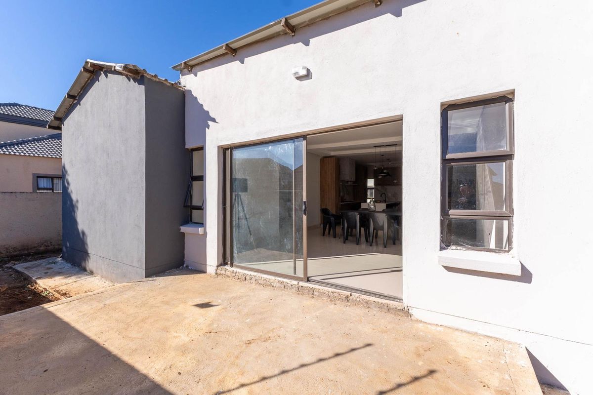 Rear view of the property featuring a sliding door entrance leading to an unfinished concrete patio area.