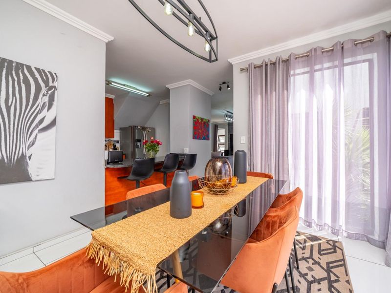 Open plan dining area featuring tiled flooring and direct access to the patio, seamlessly flowing into the adjacent kitchen space.