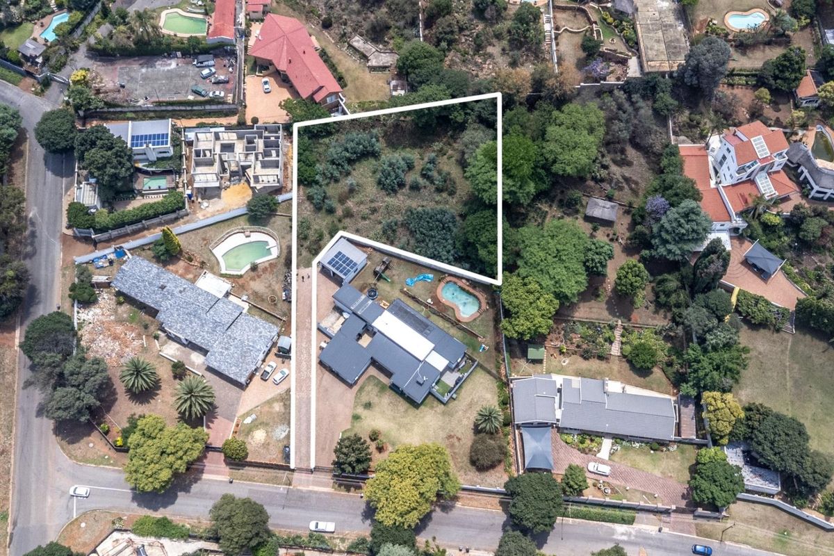 Aerial view of the property showing the main dwelling, swimming pool, and surrounding landscaped garden area within the residential estate.