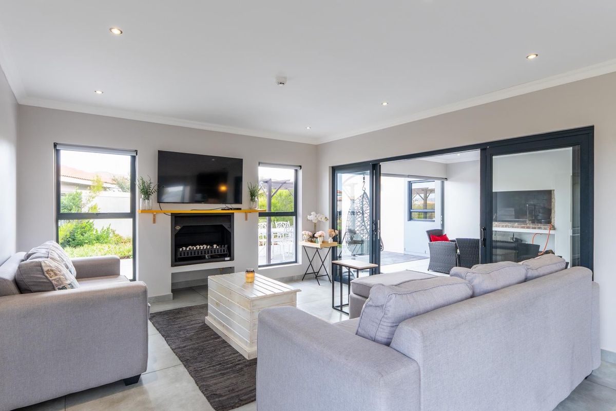 Spacious living room featuring a built-in fireplace, tiled flooring, and large sliding glass doors that open onto a covered patio area.