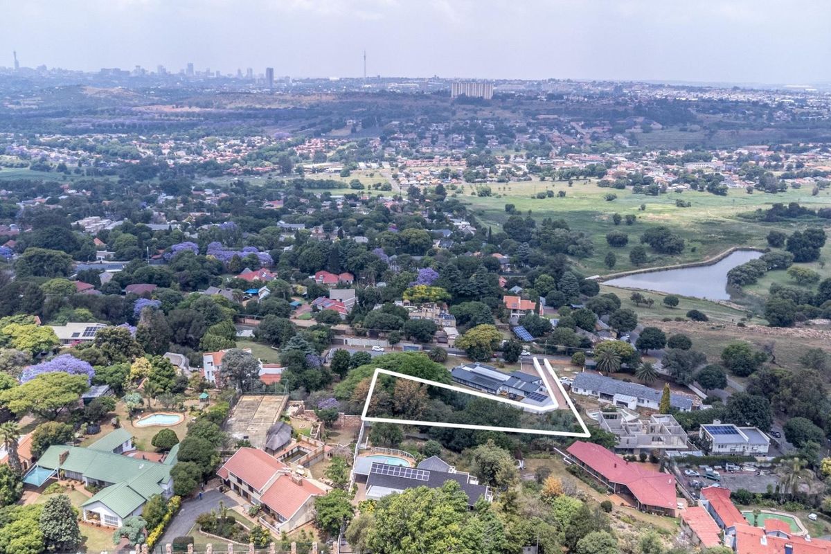 Aerial view of the property and surrounding residential neighborhood, highlighting the plot boundaries and local landscape.