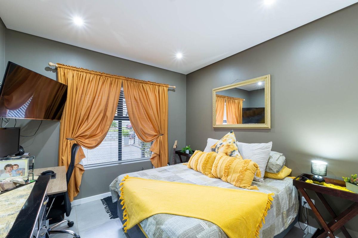 A well-maintained bedroom featuring tiled flooring, recessed ceiling lighting, and a window with curtain rod fixtures.