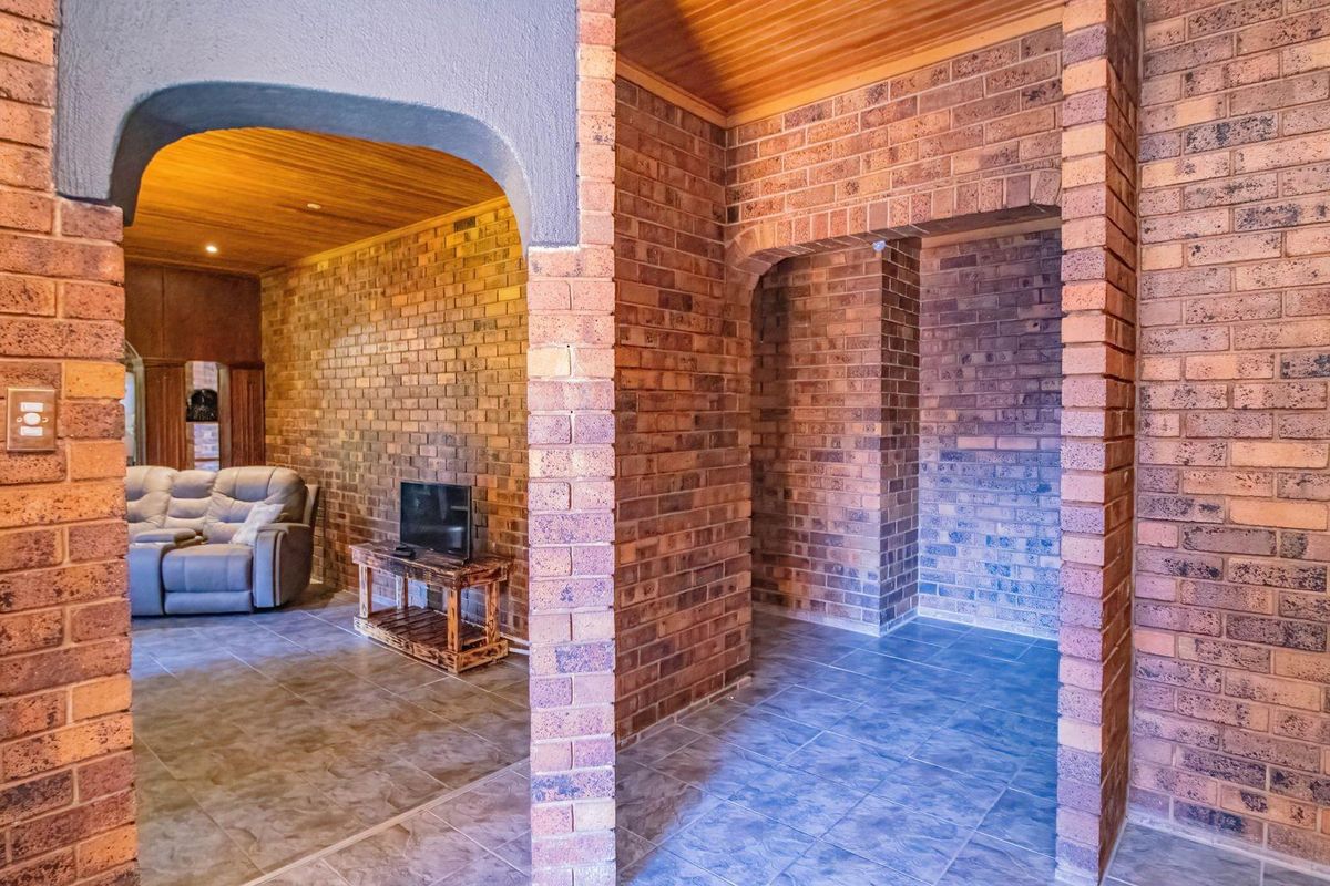 Interior view featuring exposed brick walls, arched doorways, and timber-lined ceilings, creating a rustic and character-filled living space.