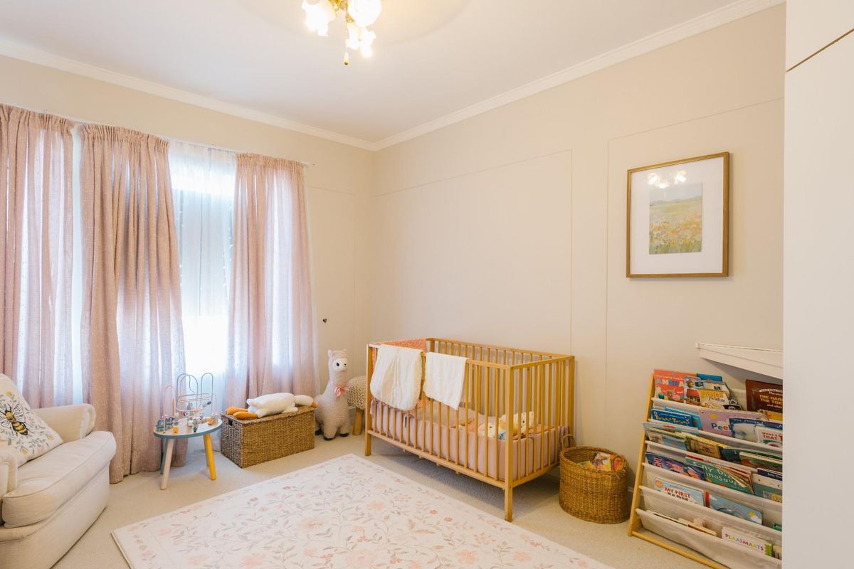 A bright and well-maintained bedroom featuring neutral wall finishes, carpeted flooring, and built-in wardrobe storage.
