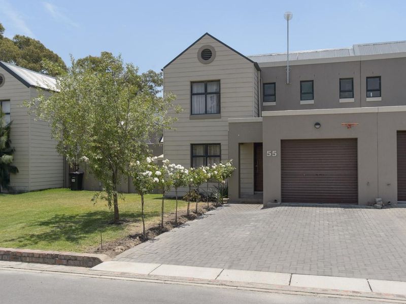 Front elevation of a two-story residential property featuring a paved driveway, single roller garage door, and low-maintenance exterior cladding.