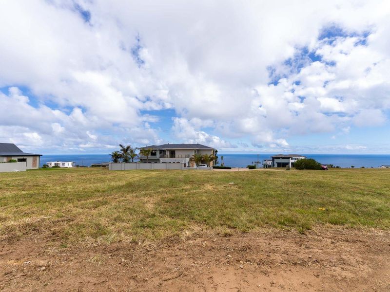 A wide-angle view of the vacant residential land featuring expansive ocean vistas and surrounding coastal neighborhood development.