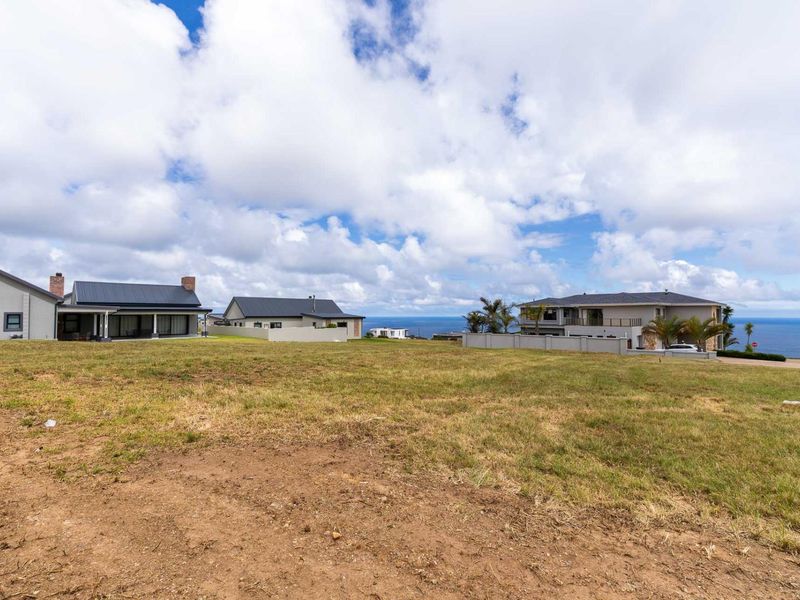 A spacious vacant residential plot situated in a developed neighborhood, offering clear coastal views and established boundary walls.