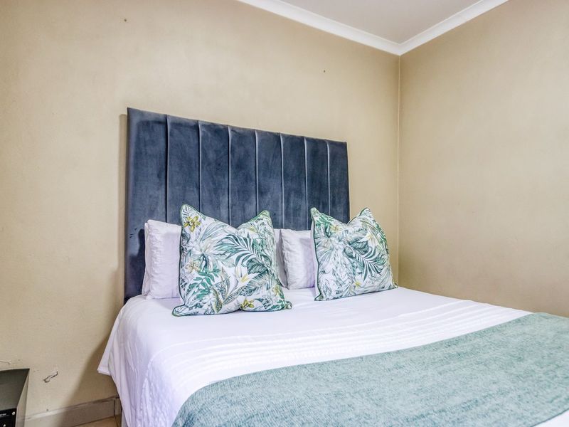 A cozy bedroom featuring neutral wall tones and classic cove cornicing, providing a comfortable and well-maintained sleeping space.