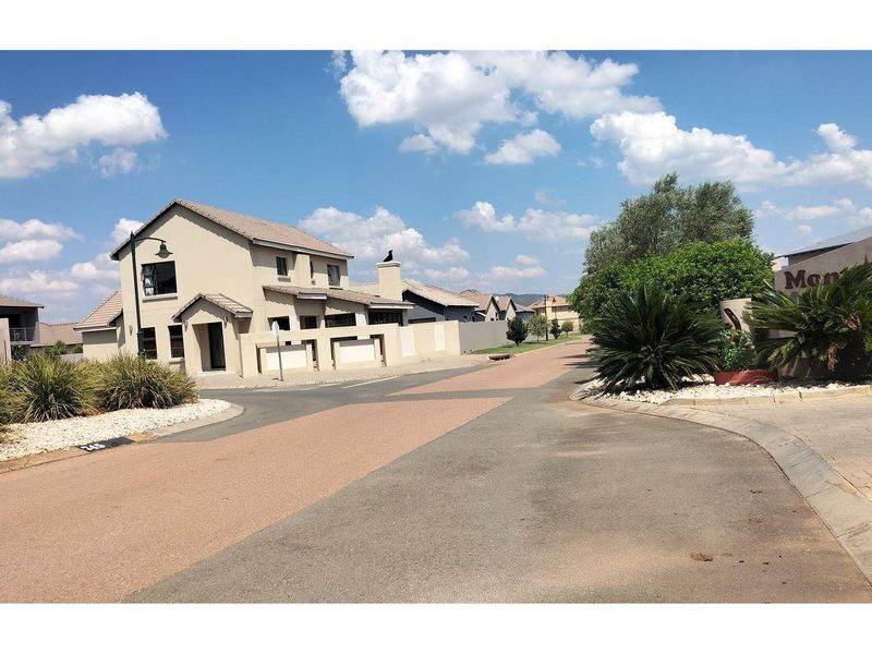 A view of the residential street and entrance area within the Mont Vista estate, featuring paved roads and established landscaping.