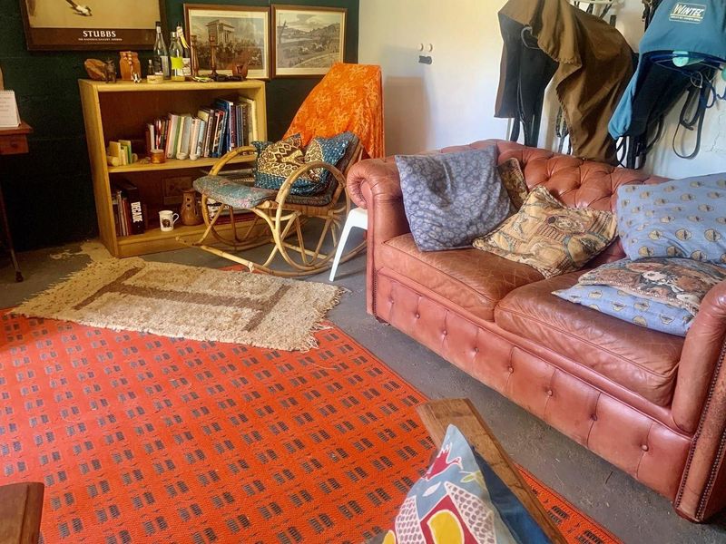 A cozy living area featuring dark painted walls and concrete flooring, suitable for a relaxed farm-style interior.