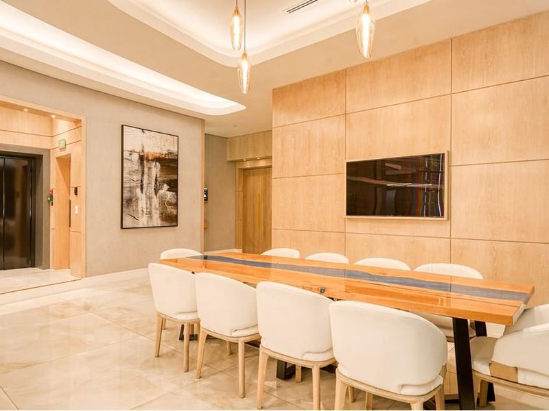Elegant dining area featuring polished marble flooring, warm wood wall paneling, recessed cove lighting, and direct private elevator access.