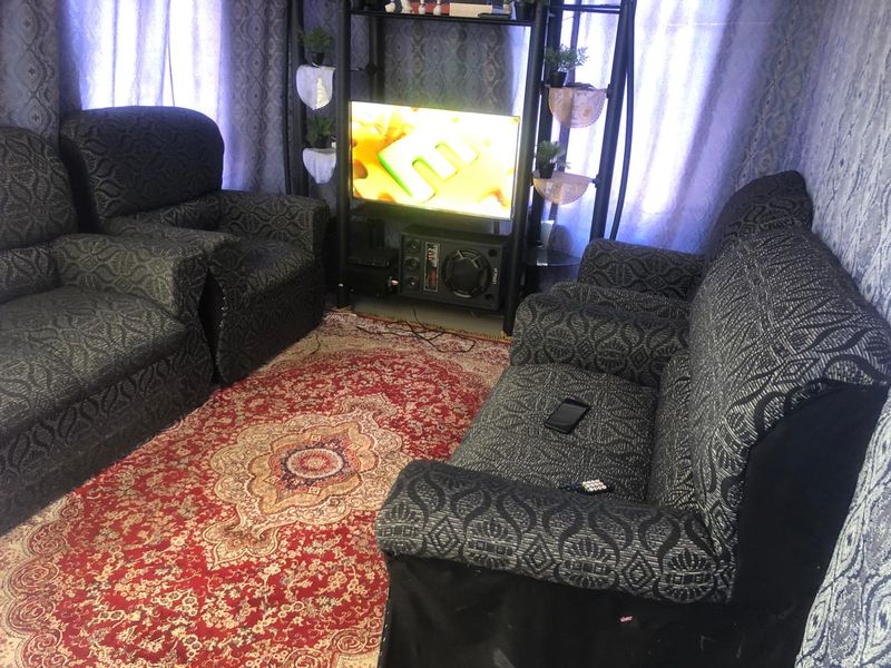 A living room space featuring patterned wall coverings and curtains.