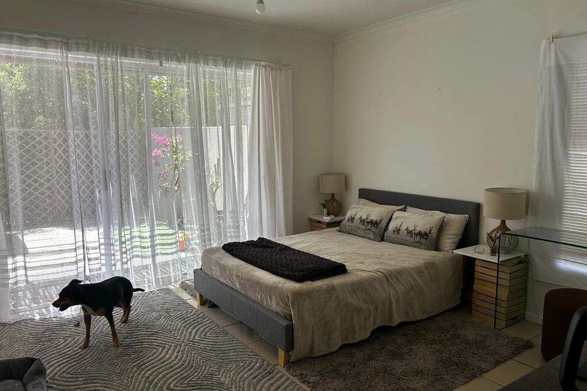 A bedroom featuring tiled flooring and a large sliding glass door providing direct access to the outdoor area.