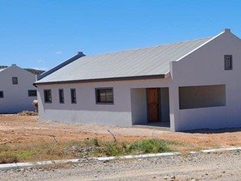 Exterior view of two newly constructed single-story residential houses featuring gabled roofs and neutral rendered facades in a developing area.