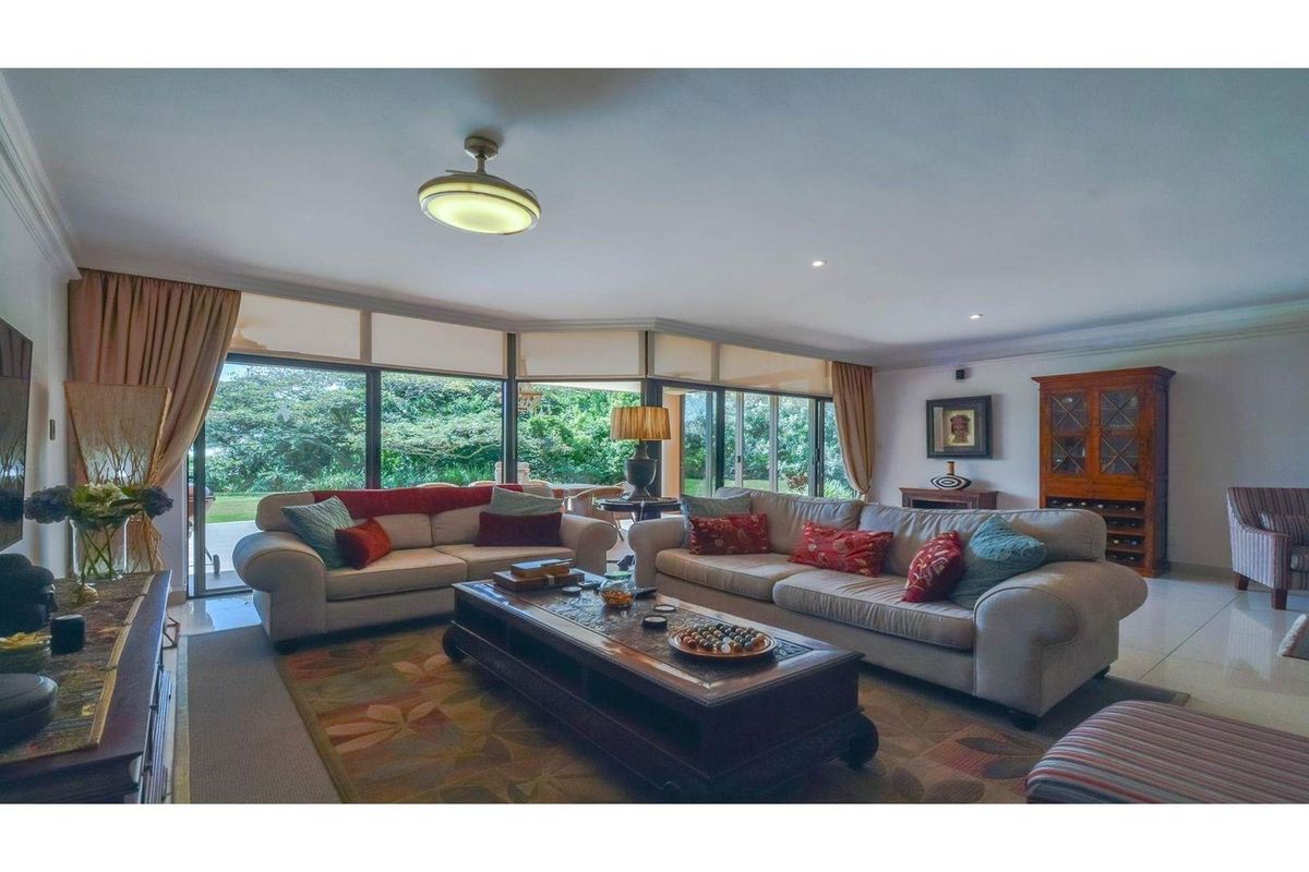 Spacious living room featuring large floor-to-ceiling glass sliding doors that provide abundant natural light and direct access to the outdoor area.