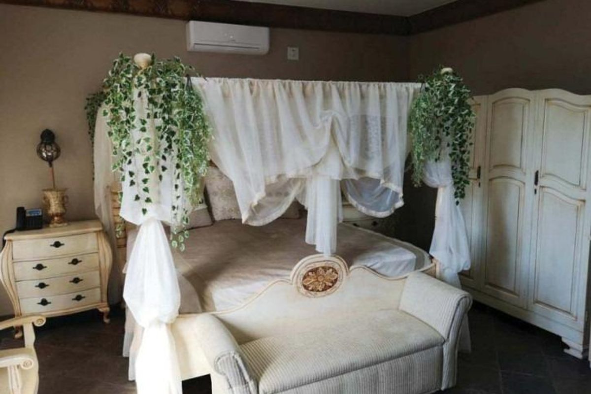 A bedroom featuring tiled flooring, recessed downlighting, and a wall-mounted split-system air conditioning unit.