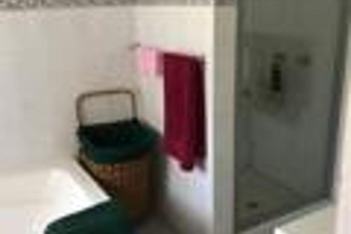 A functional bathroom featuring a built-in bathtub, a separate glass-enclosed shower, and tiled flooring.
