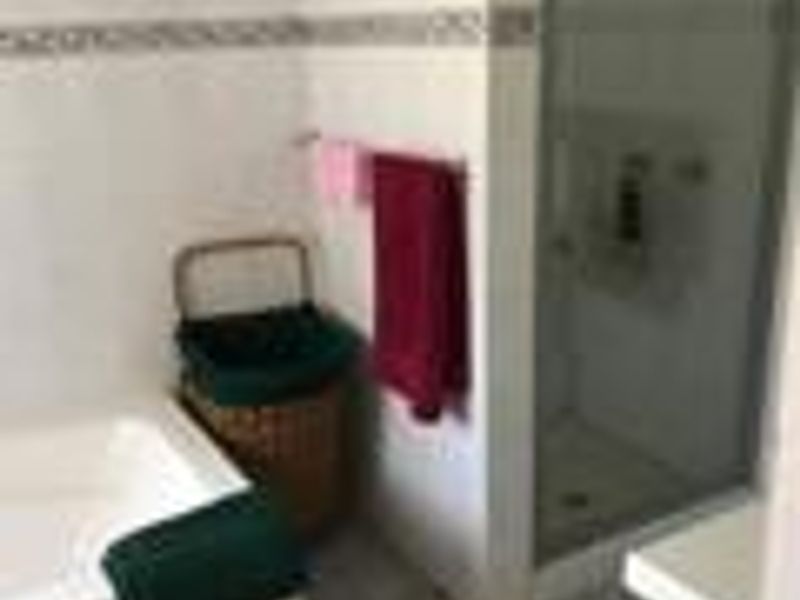 A functional bathroom featuring a built-in bathtub, a separate glass-enclosed shower, and tiled flooring.