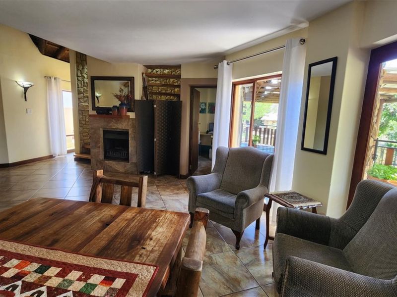 A living room featuring tiled flooring, a stone fireplace, and a sliding glass door providing access to an outdoor area.