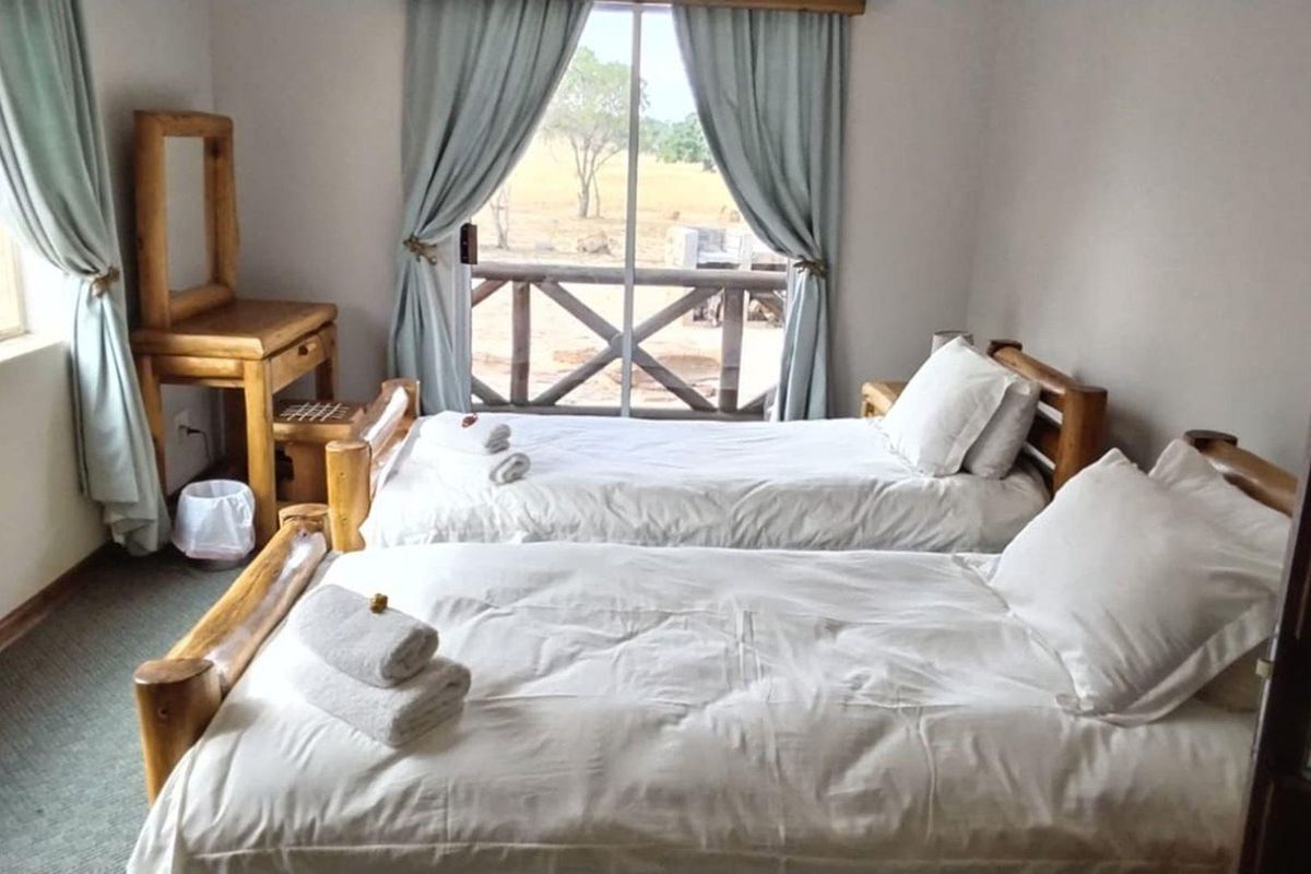 A bedroom featuring carpeted flooring and a sliding glass door that opens onto a private patio with views of the surrounding farm landscape.