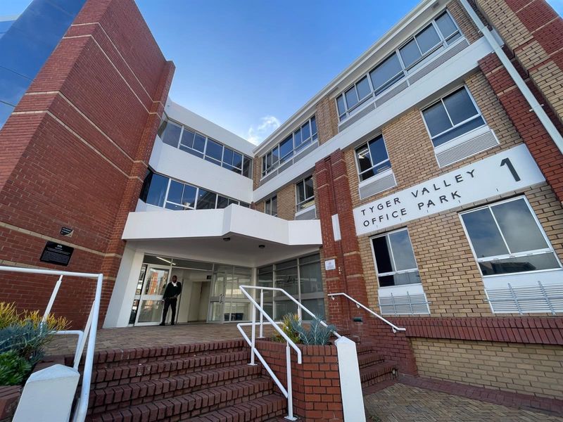Front entrance view of Tyger Valley Office Park building 1, featuring a brick facade, paved steps, and a covered entrance canopy.