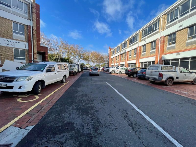 Exterior view of the Valley Park office complex featuring brick facade buildings, paved parking bays, and access road.