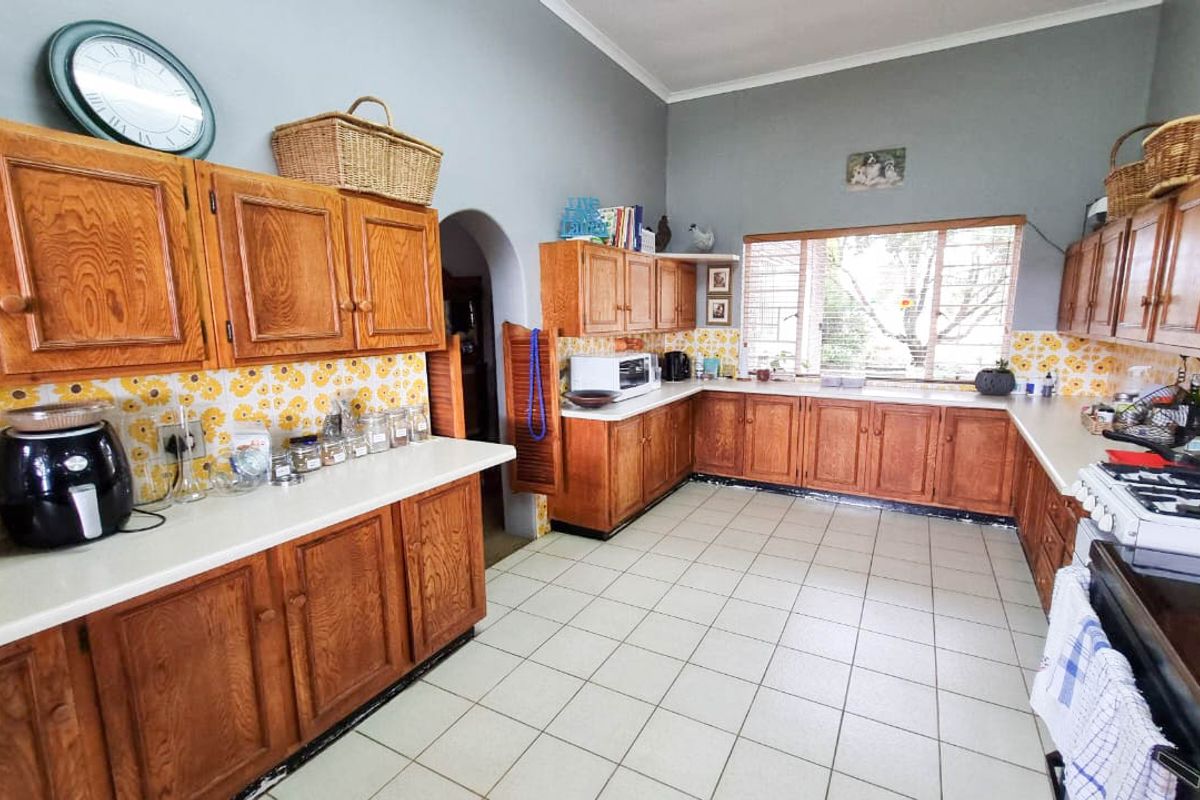 Spacious kitchen featuring traditional wooden cabinetry, tiled flooring, and a gas stove, offering a functional layout with potential for modern updates.