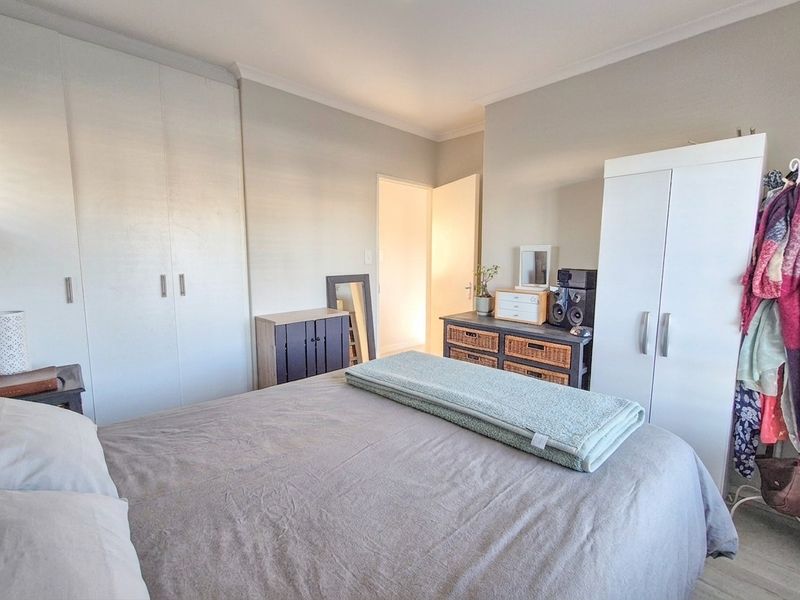 A functional bedroom featuring built-in cupboards and neutral wall finishes, providing a practical and comfortable living space.