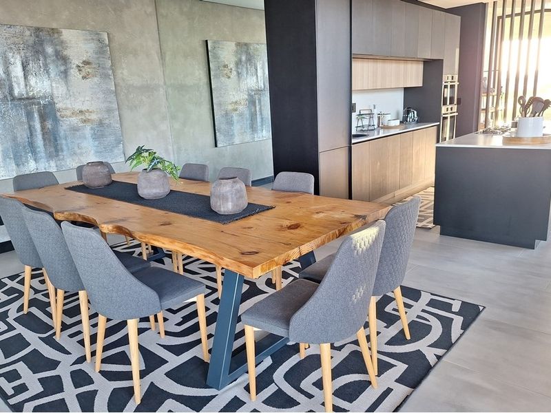 Modern open-plan living space featuring a sleek kitchen with built-in cabinetry, a central island, and a spacious dining area with contemporary finishes.