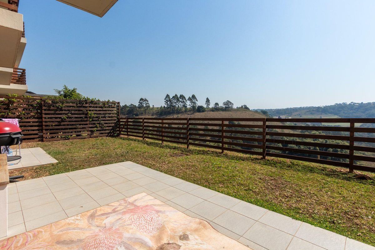 A private rear patio area featuring tiled flooring and timber perimeter fencing, offering open views of the surrounding landscape.