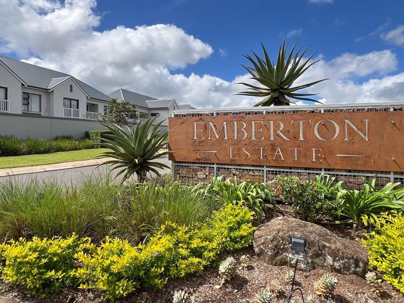 The entrance to Emberton Estate featuring professional signage, well-maintained landscaping, and a clear view of the residential complex facade.