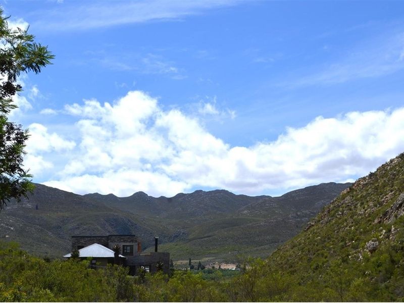 A scenic landscape view showcasing the expansive mountain range and natural terrain surrounding the property.