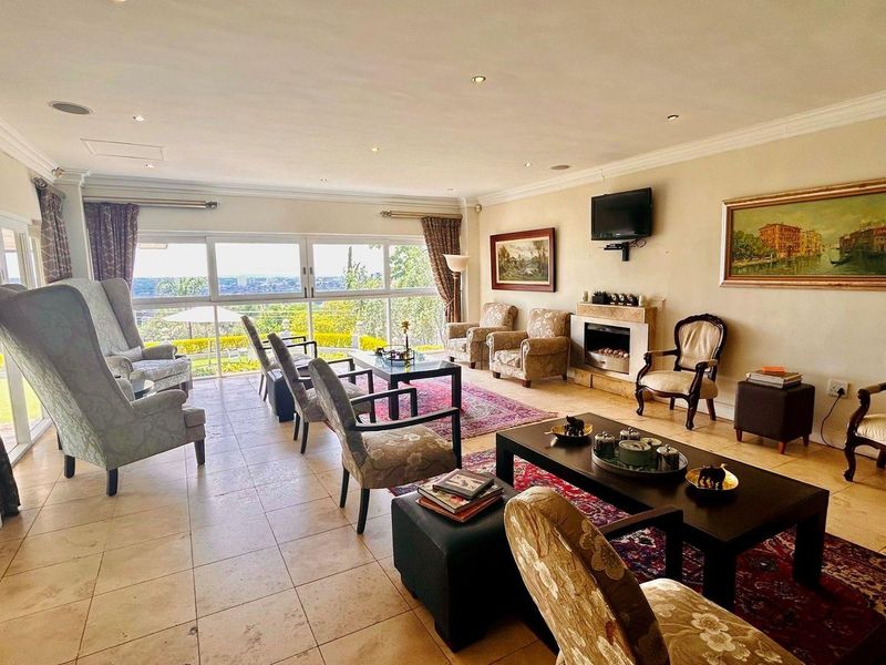 Spacious living room featuring large sliding glass doors with scenic views, tiled flooring, recessed lighting, and a built-in fireplace.