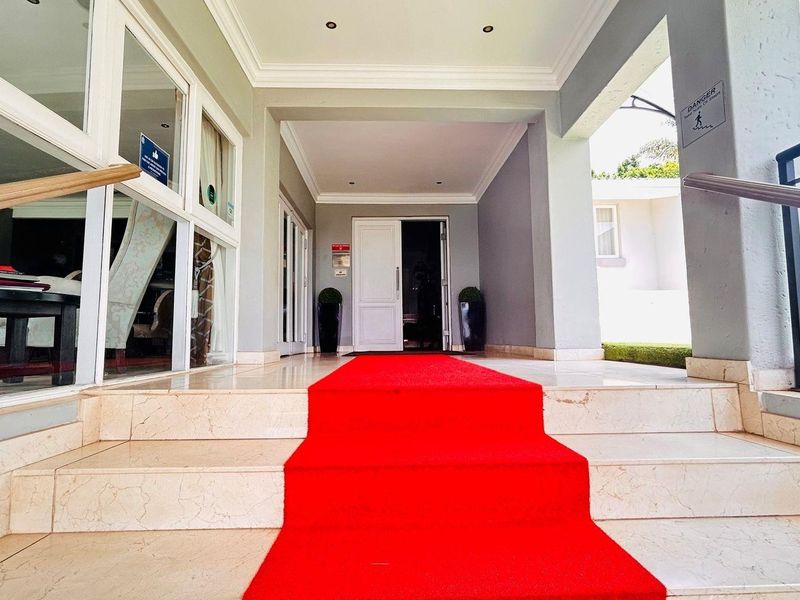 A welcoming covered entrance featuring tiled steps, a grand doorway, and a sheltered porch area leading into the main residence.