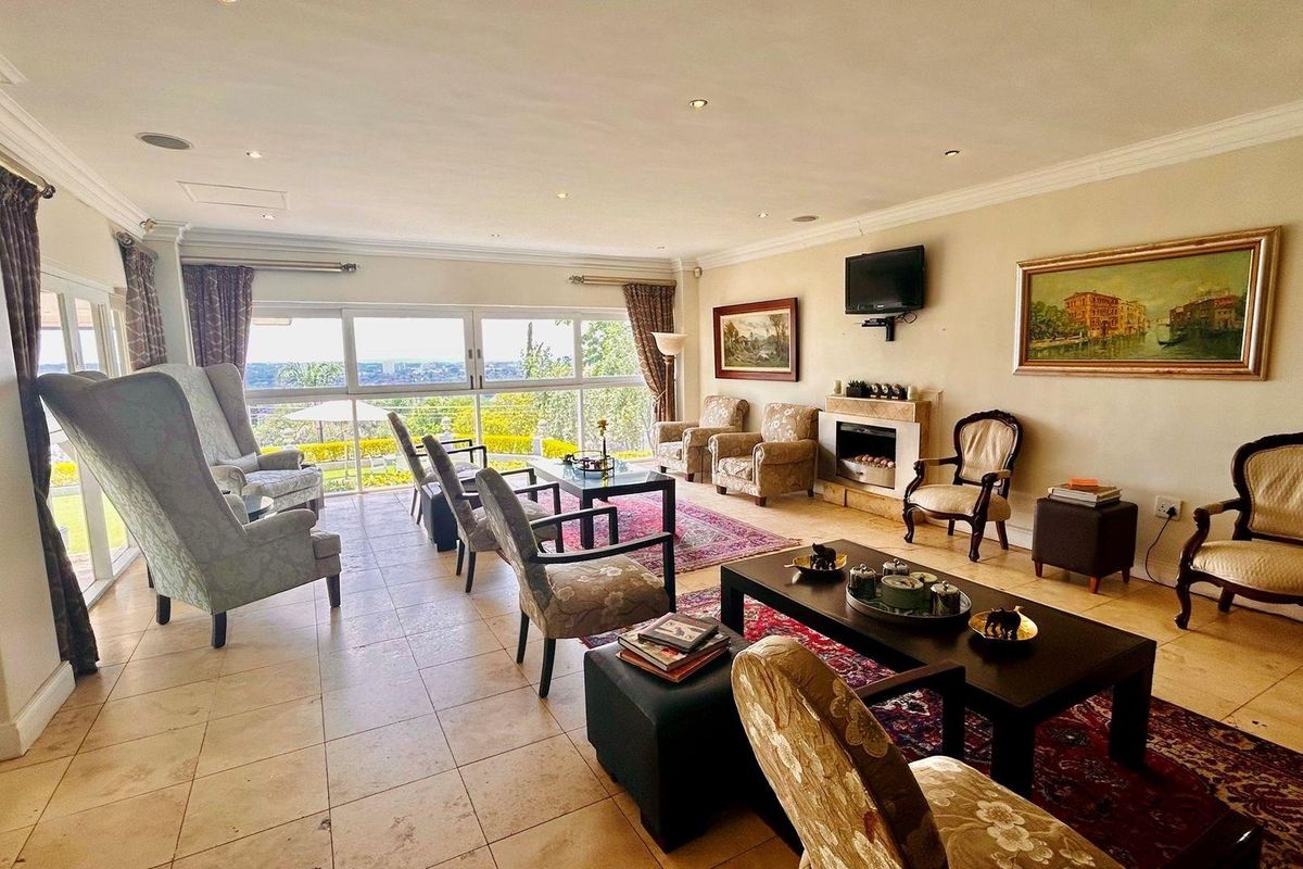 Spacious living room featuring large sliding glass doors with scenic views, tiled flooring, recessed lighting, and a built-in fireplace.