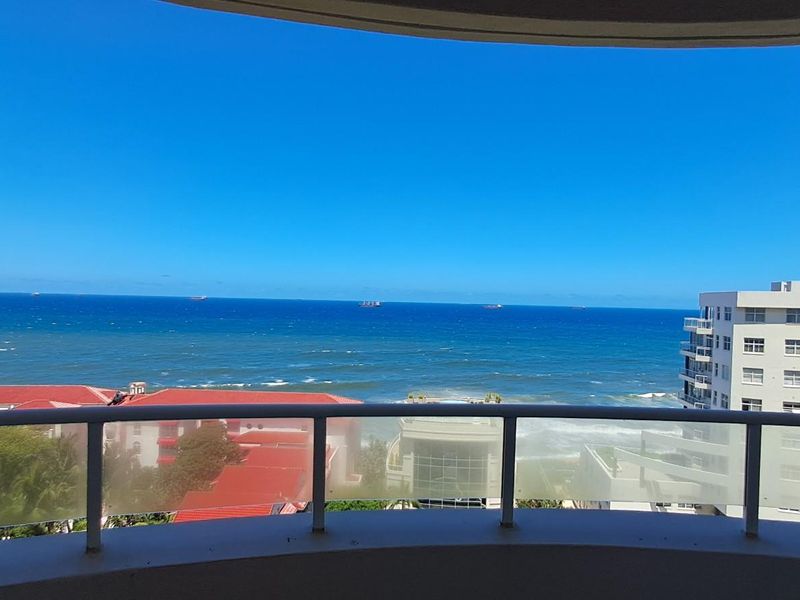 A spacious balcony offering expansive, unobstructed views of the ocean and surrounding coastal cityscape.
