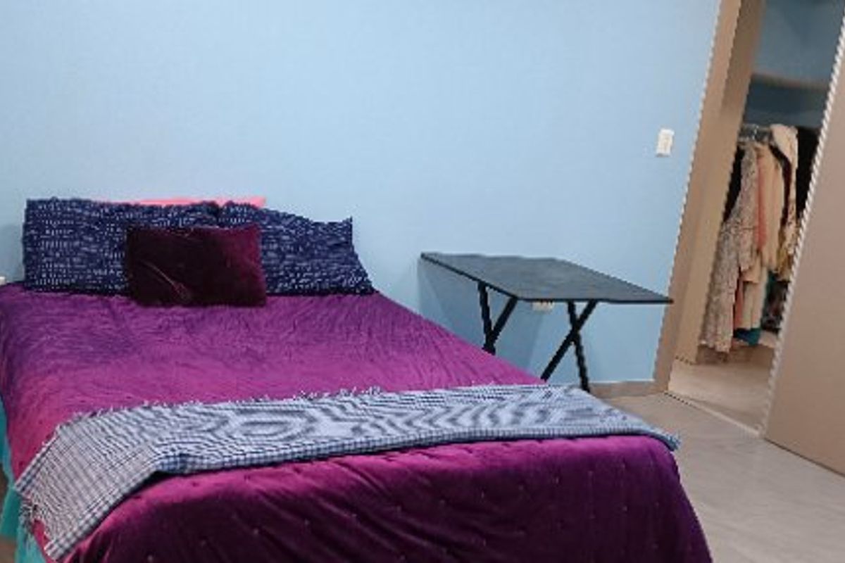A bedroom featuring tiled flooring and a built-in wardrobe with an adjacent walk-in closet area.