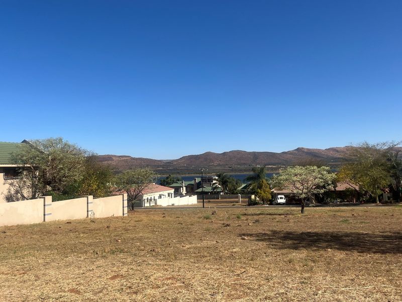 A vacant residential plot offering scenic mountain and water views, situated within an established neighborhood setting.