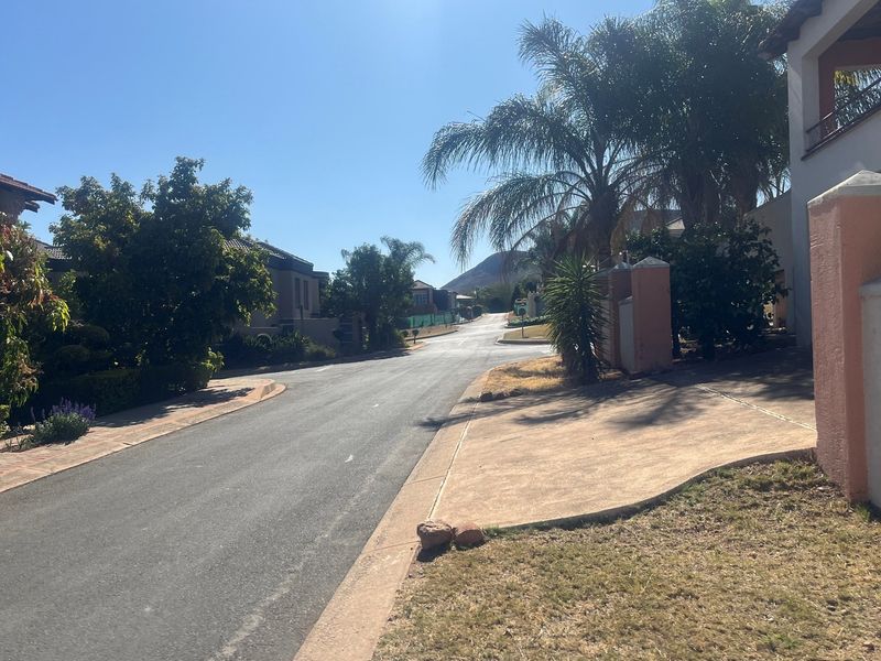 A view of the residential street within the estate, showing paved roads, sidewalks, and established landscaping.