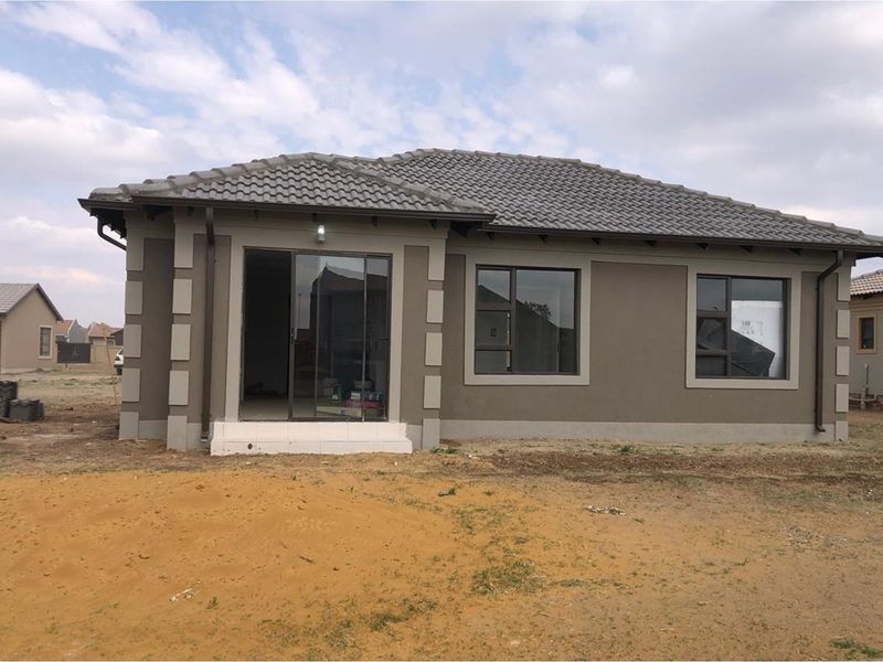 A modern single-story residential house featuring a tiled roof, neutral exterior paint, and aluminium-framed windows with a sliding glass door entrance.