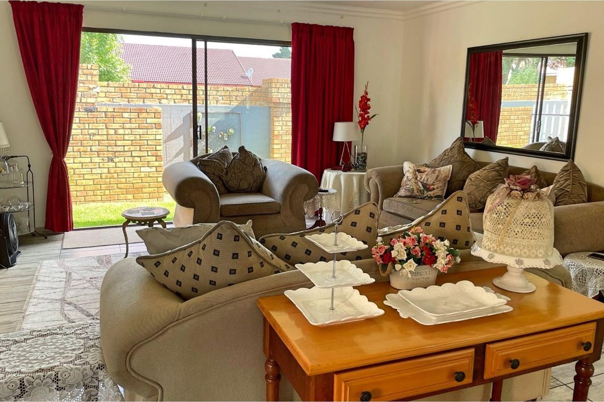 A comfortable living room featuring large sliding glass doors that provide direct access to the rear patio and garden area.