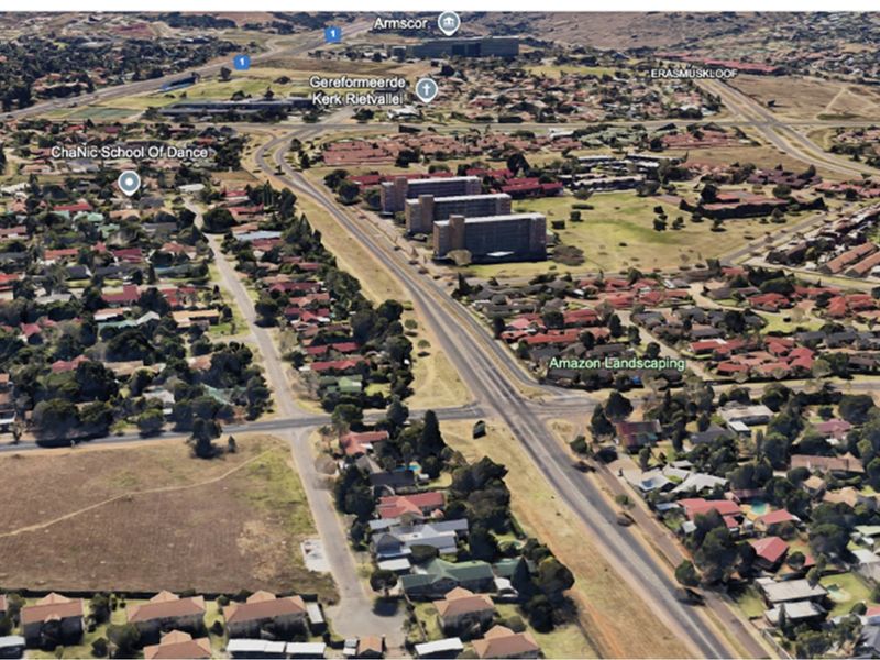 An aerial view of the residential neighborhood and surrounding infrastructure, showcasing the local layout and proximity to main roads.