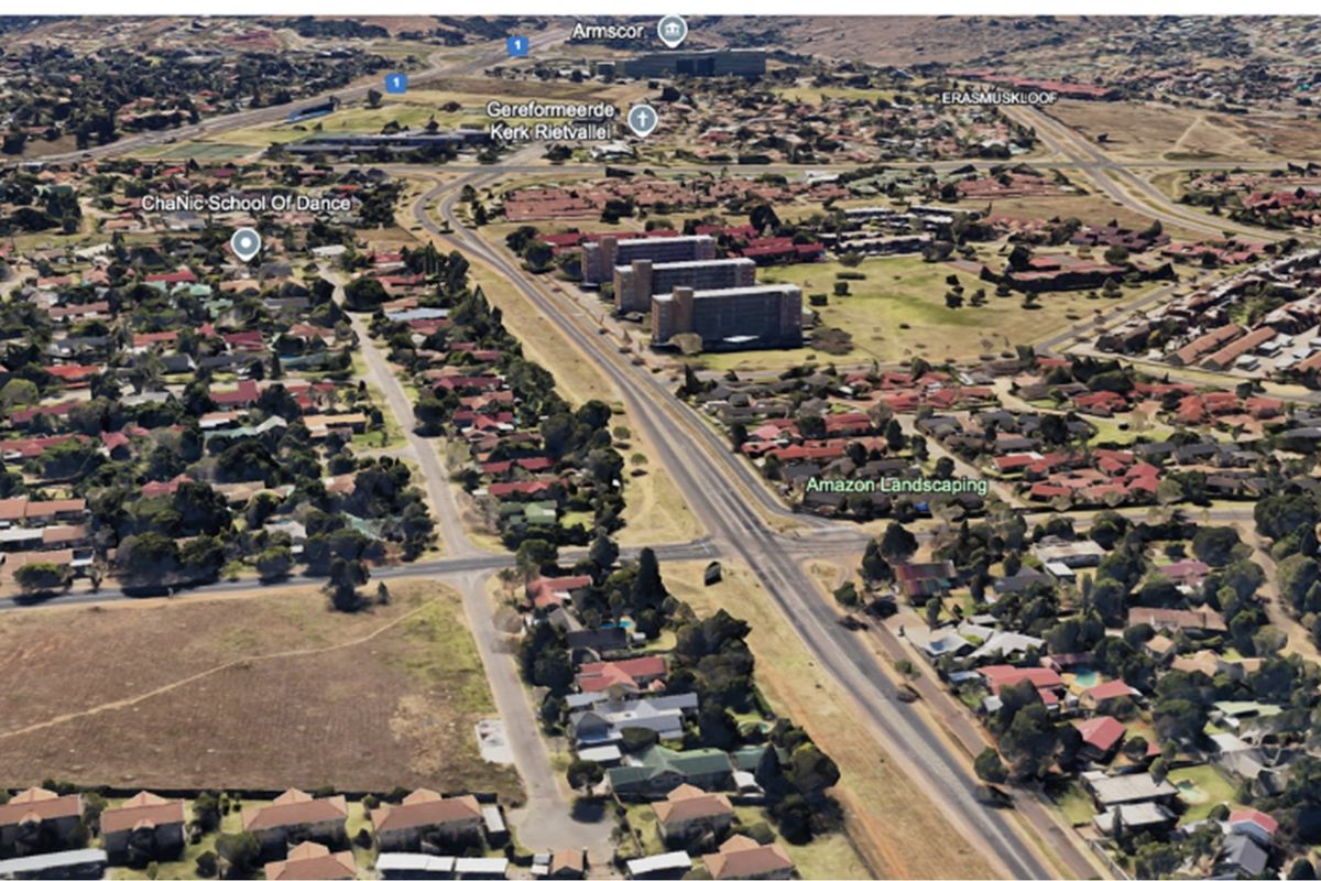 An aerial view of the residential neighborhood and surrounding infrastructure, showcasing the local layout and proximity to main roads.