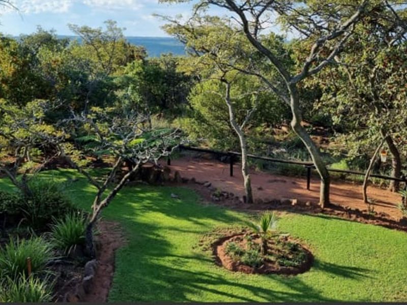 A well-maintained garden area featuring lush green lawns, landscaped beds, and mature trees, offering a serene outdoor space with natural surroundings.